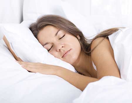 Femme qui dort dans son lit